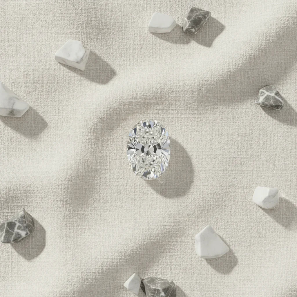 Oval cut loose diamond on textured fabric with marble accents, ideal for bespoke engagement rings