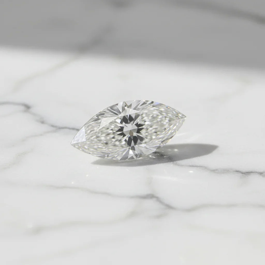 Sparkling marquise cut loose diamond on white marble, perfect for bespoke engagement rings