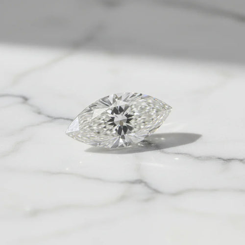 Sparkling marquise cut loose diamond on white marble, perfect for bespoke engagement rings