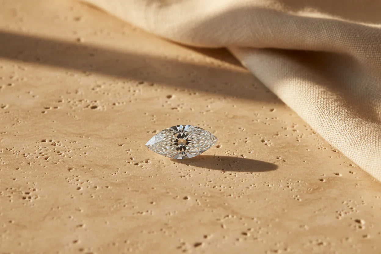 Sparkling marquise cut loose diamond on textured stone surface, ideal for bespoke engagement rings