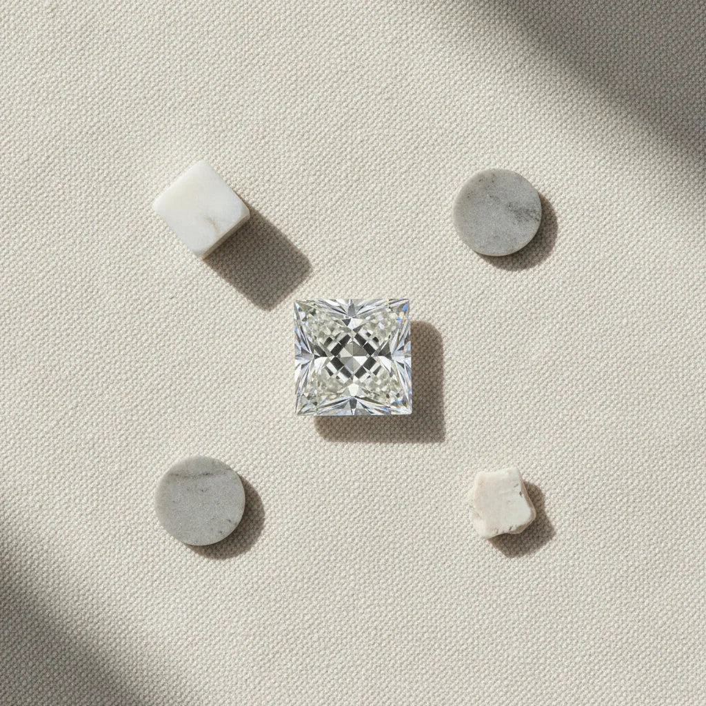 Sparkling princess cut loose diamond on textured surface with marble accents, ideal for bespoke engagement rings