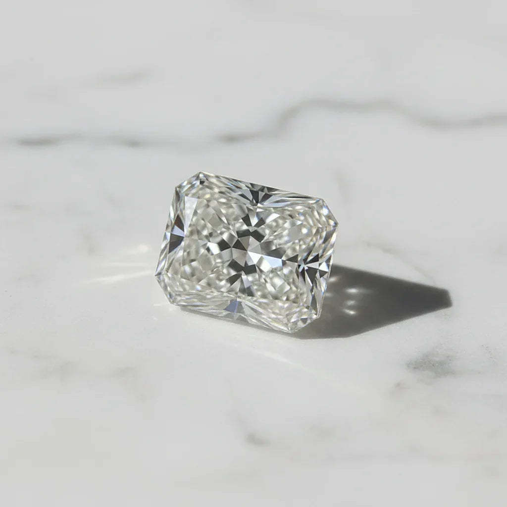 Radiant cut loose diamond on marble surface, ideal for bespoke engagement rings and jewellery